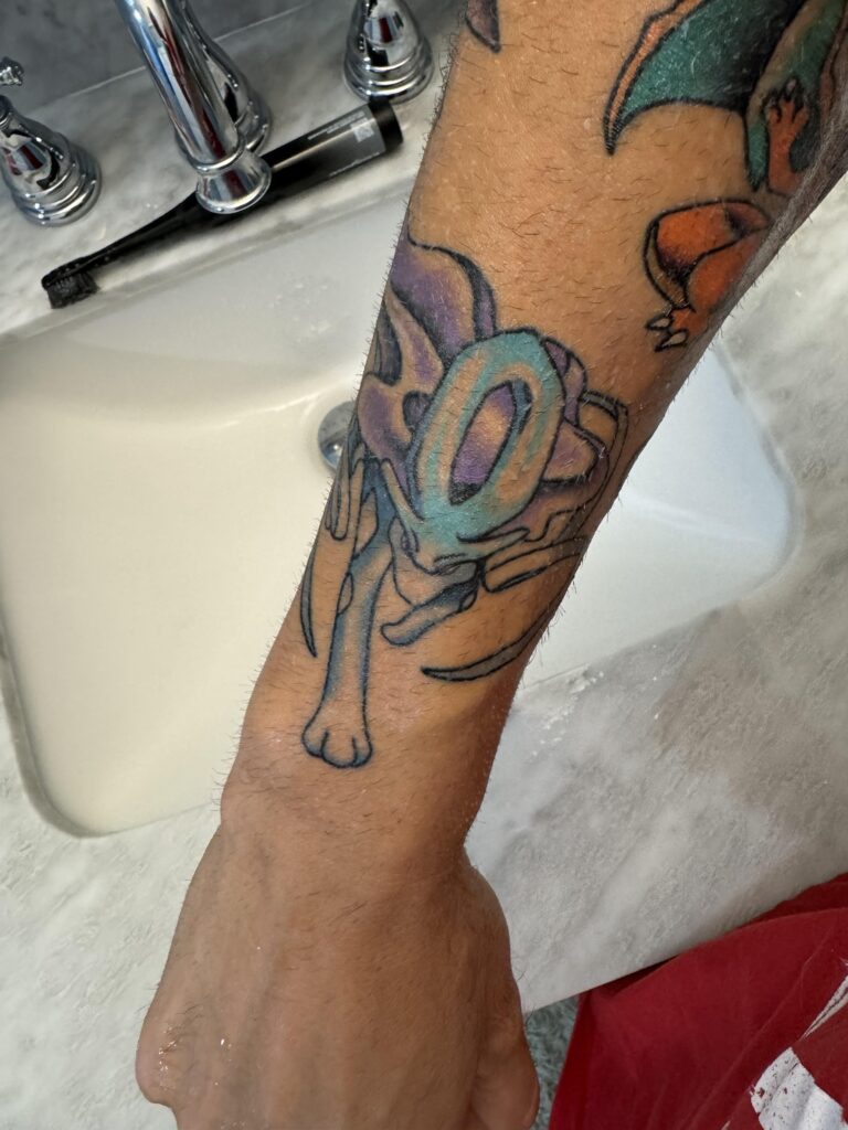 I was waiting till it was done peeling to take a decent picture  I got the Suicune from the cover of Pokémon crystal tattooed on me because of how much this game meant to me when I was a kid . It’s pure nostalgia