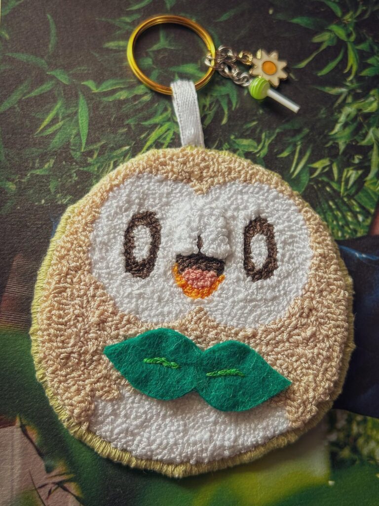 punch needle art, rowlet keychain and porygon2 button!